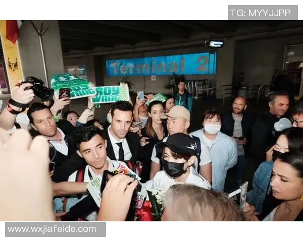 足球明星机场接电话引围观粉丝争相拍照记录精彩瞬间